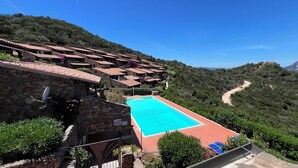 A hillside villa with a swimming pool, stone walls, and terracotta roofs. - Blue Dawn - Holiday home with cozy terrace, garden & wonderful sea view. (Capo Coda Cavallo)