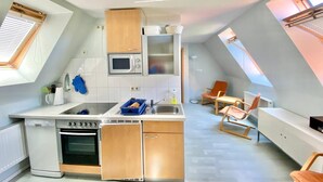 A compact kitchen with a microwave, oven, and wooden cabinets.