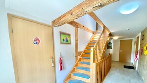 A wooden staircase with blue steps leading to a second floor.