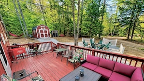 A wooden deck with outdoor furniture, a red Coca-Cola cooler, and a small shed. - Dog Friendly 🐾 Sleeps 8 • Near North Conway & Kancamangus Hwy. • Lake Access (Madison)