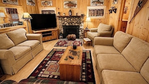 A cozy living room with a fireplace, two sofas, a coffee table, and a TV. - Dog Friendly 🐾 Sleeps 8 • Near North Conway & Kancamangus Hwy. • Lake Access (Madison)