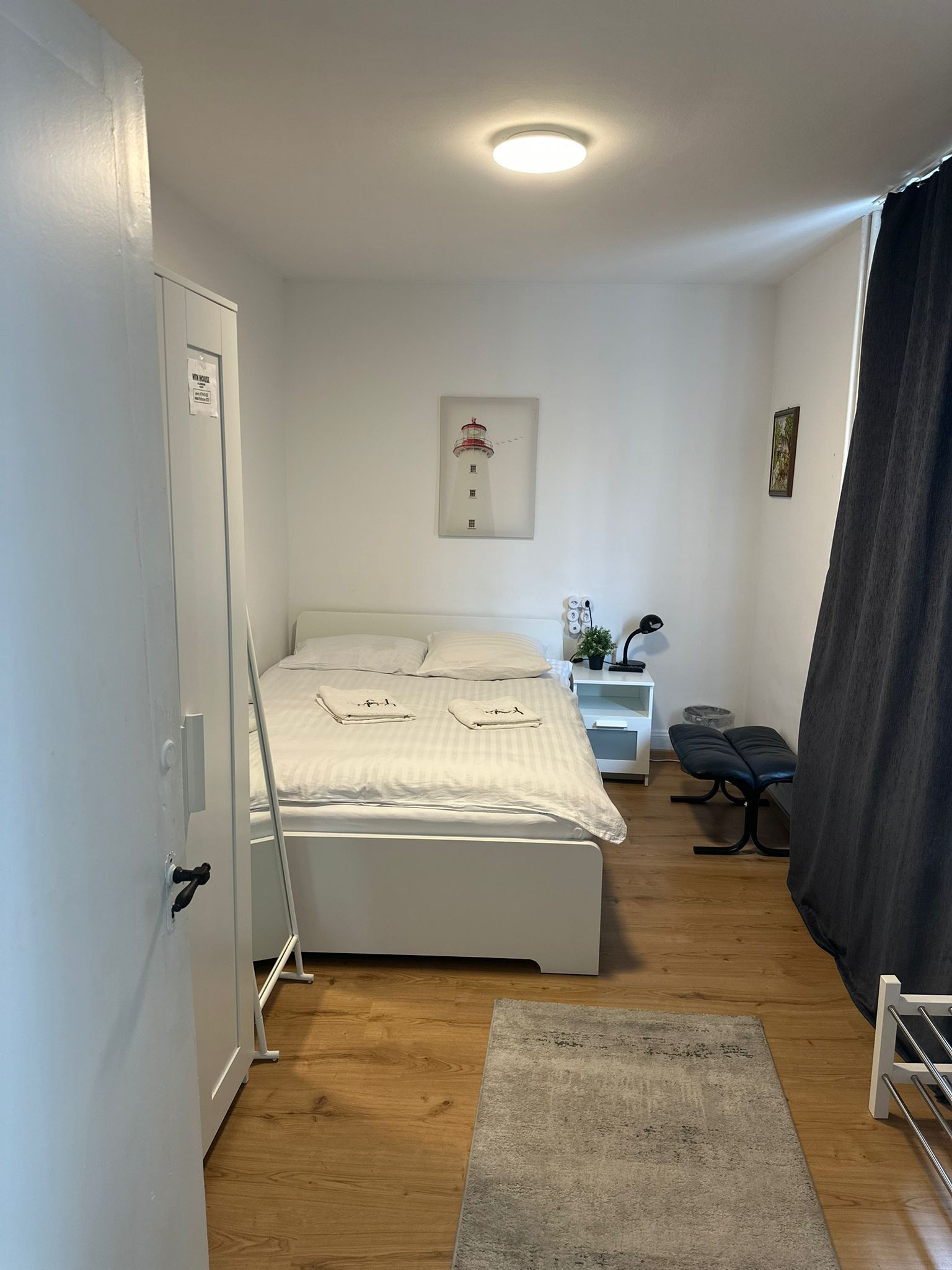 Une chambre à coucher avec un lit, une table de chevet, une lampe et un tableau au mur.
