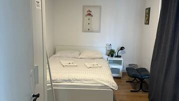 Une chambre à coucher avec un lit, une table de chevet, une lampe et un tableau au mur.