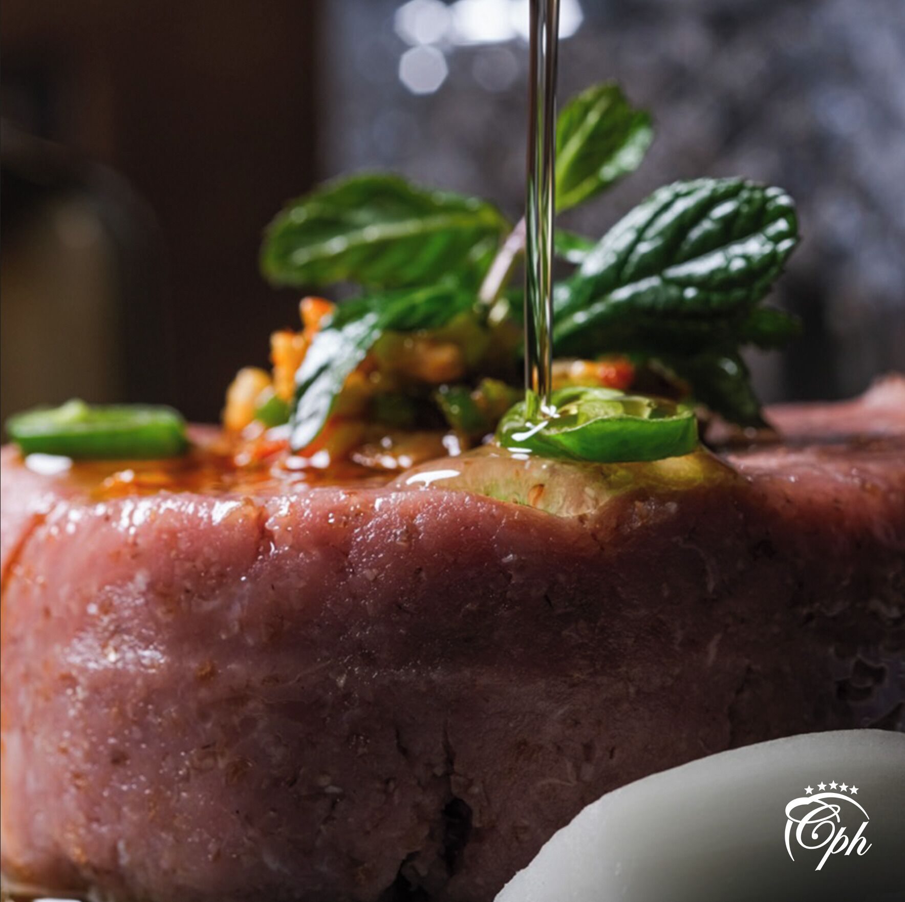 A close-up of a dish with a glossy sauce, garnished with green leaves and herbs.