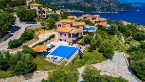 A hillside property with multiple buildings, a swimming pool, and a view of the sea. - Villa Andromeda-Pegasus (Sivota)