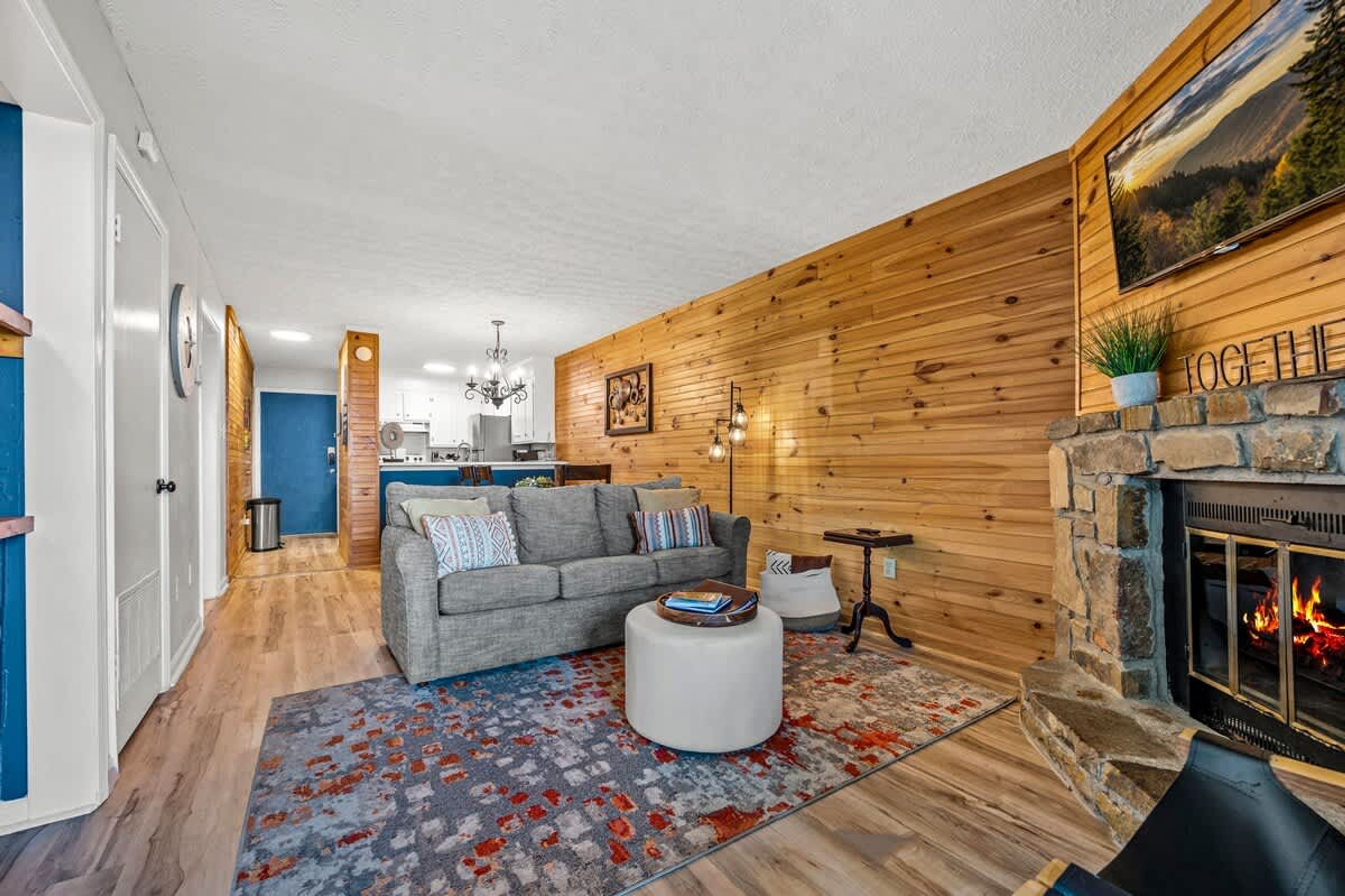 A cozy living room with a fireplace, a sofa, and a rug.