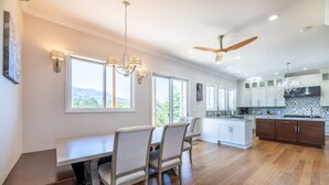 Una cocina amplia con comedor, ventanas grandes y ventilador de techo.