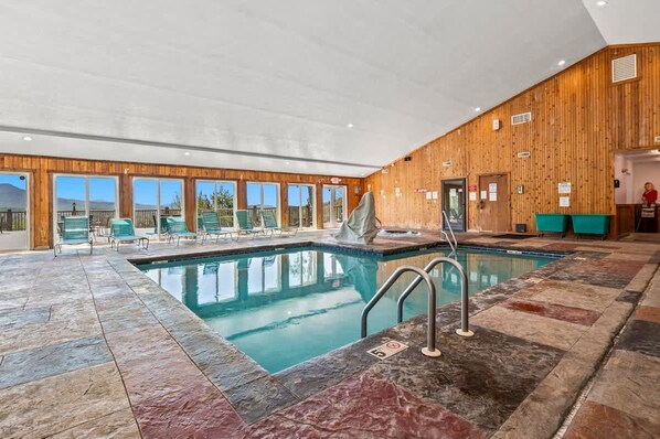 An indoor swimming pool with a wooden interior, clear windows, and a view of the mountains. - Sleeps 6 Indoor Pool Playground Hot Tub (Gatlinburg)