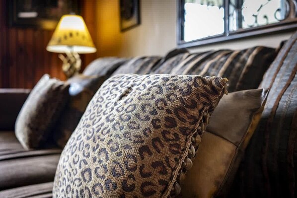 A sofa with a leopard print pillow and a lamp in the background. - Sleeps 4 Hot Tub Indoor Pool Mountain Views (Gatlinburg)