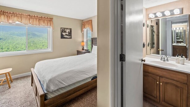 A bedroom with a large window, a bed, a nightstand, and a view of the outdoors. - Sleeps 6 Indoor Pool Hot Tub Mountain Views (Gatlinburg)