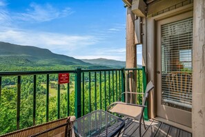 A balcony with a view of green hills, a 'No Grilling/Smoking' sign, and a chair. - Sleeps 6 Indoor Pool Hot Tub Mountain Views (Gatlinburg)