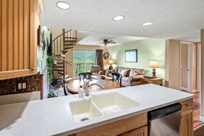A spacious kitchen with a large island, wooden cabinetry, and a built-in dishwasher. - Sleeps 8 Pool Playground Mountain Views Hot Tub (Gatlinburg)