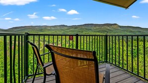 A balcony with a view of green hills under a clear sky. - Sleeps 8 Pool Playground Mountain Views Hot Tub (Gatlinburg)
