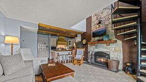 A spacious living room with a fireplace, a dining area, and a kitchen in the background. - Sleeps 6 Pool Playground Mountain Views Hot Tub (Gatlinburg)