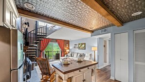 A spacious kitchen with a wooden island, a built-in refrigerator, and a staircase leading to a balcony. - Sleeps 6 Pool Playground Mountain Views Hot Tub (Gatlinburg)