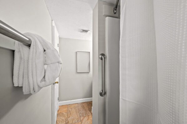 A bathroom with a towel rack, a shower curtain, and a door. - Indoor Pool Mountain Views Hot Tub Sauna (Gatlinburg)