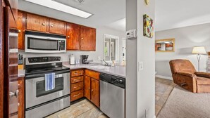 A modern kitchen with stainless steel appliances, wooden cabinets, and a dishwasher. - Indoor Pool Mountain Views Hot Tub Sauna (Gatlinburg)