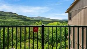 A balcony with a 'No Grilling or Smoking' sign, overlooking a lush green landscape with hills. - Sleeps 6 Mountain Views Heated Pool Playground (Gatlinburg)