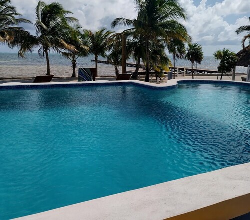 Beach front in welcoming San Pedro w/ AC, pool, fitness room, WiFi, kitchenette