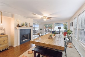 A spacious dining area with a wooden table, benches, and a fireplace.