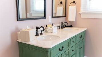A bathroom with two sinks, a mirror, and a green vanity.