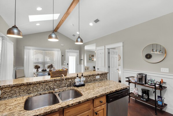 A modern kitchen with granite countertops, stainless steel appliances, and pendant lighting. - Charming 3-bedroom house in brilliant Santa Rosa Beach, 7 minutes from the beach (Santa Rosa Beach)