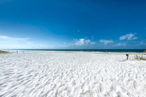 A wide sandy beach with a clear blue sky and calm sea. - Charming 3-bedroom house in brilliant Santa Rosa Beach, 7 minutes from the beach (Santa Rosa Beach)