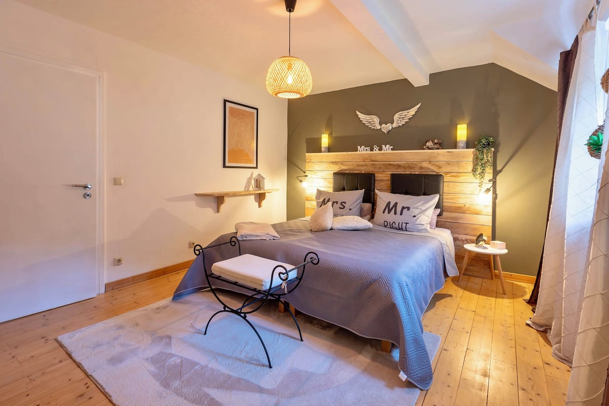 Ein Schlafzimmer mit Bett, Nachttisch und einer Pendelleuchte.