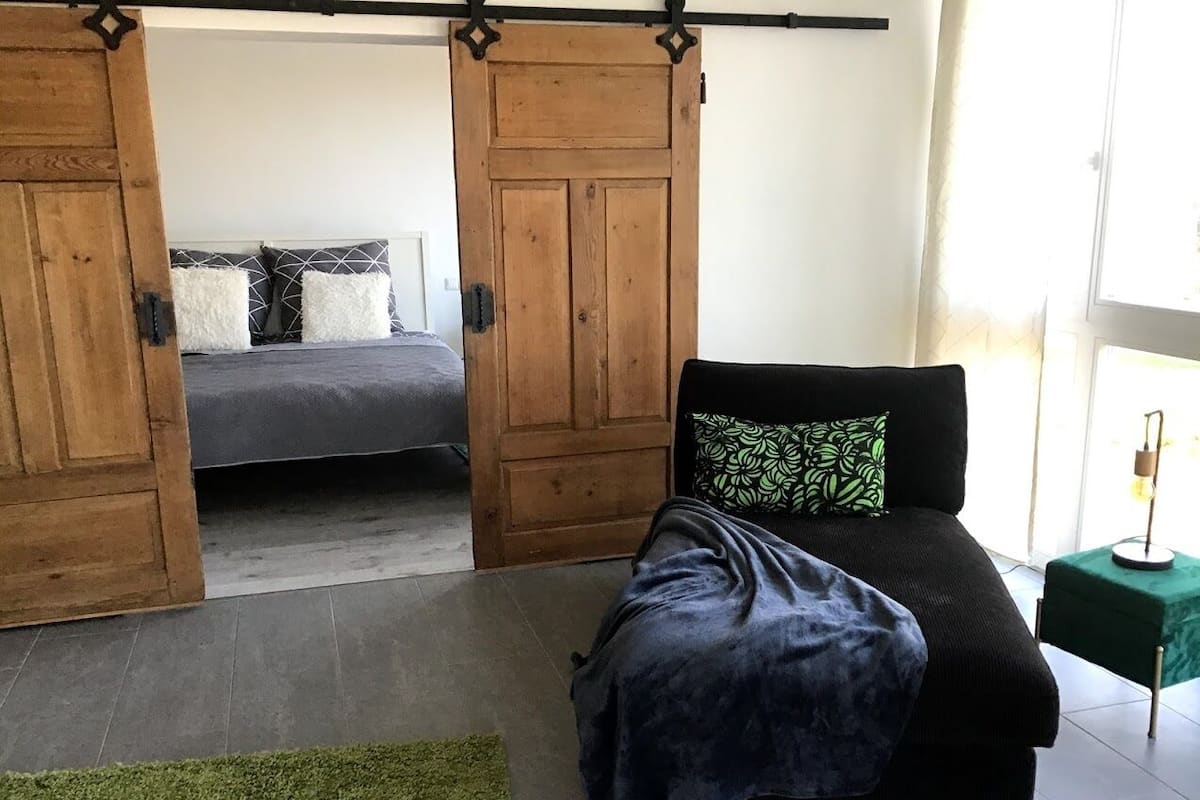 Ein Schlafzimmer mit einem Bett, einem grünen Teppich und einer Schiebetür.