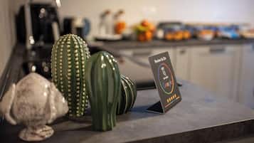 A kitchen counter with a cactus, a ceramic elephant, and a sign that reads "Review Us On Google".