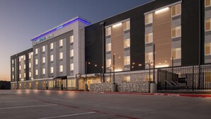 A modern hotel building with a sign reading "Everhome Suites." It features a large parking lot and a stone facade. - Everhome Suites Waco by Choice Hotels (Waco)