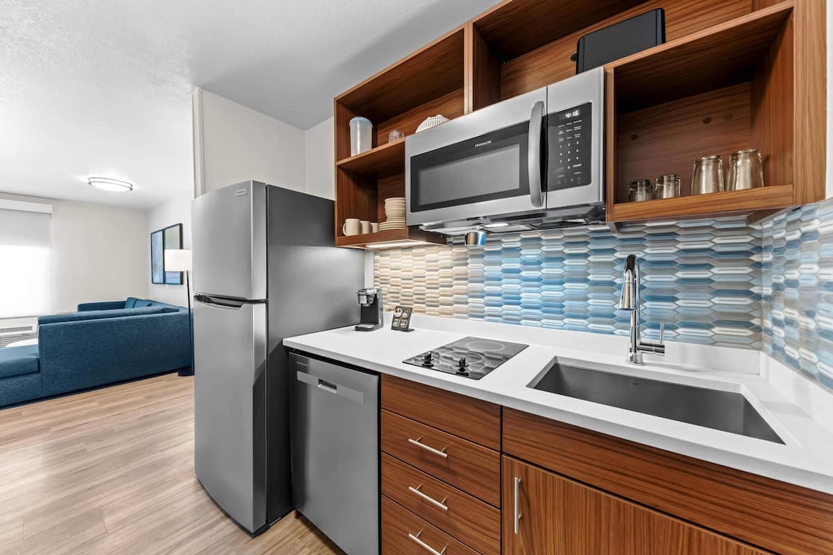 A modern kitchen with a built-in microwave, refrigerator, and dishwasher.