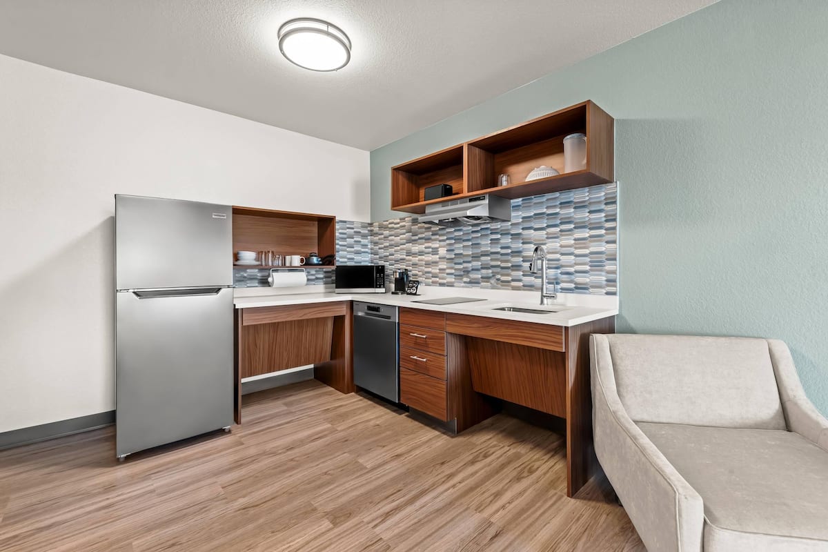 A modern kitchen with a built-in refrigerator, microwave, and dishwasher.