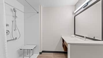 A modern bathroom with a shower, a sink, and a mirror.