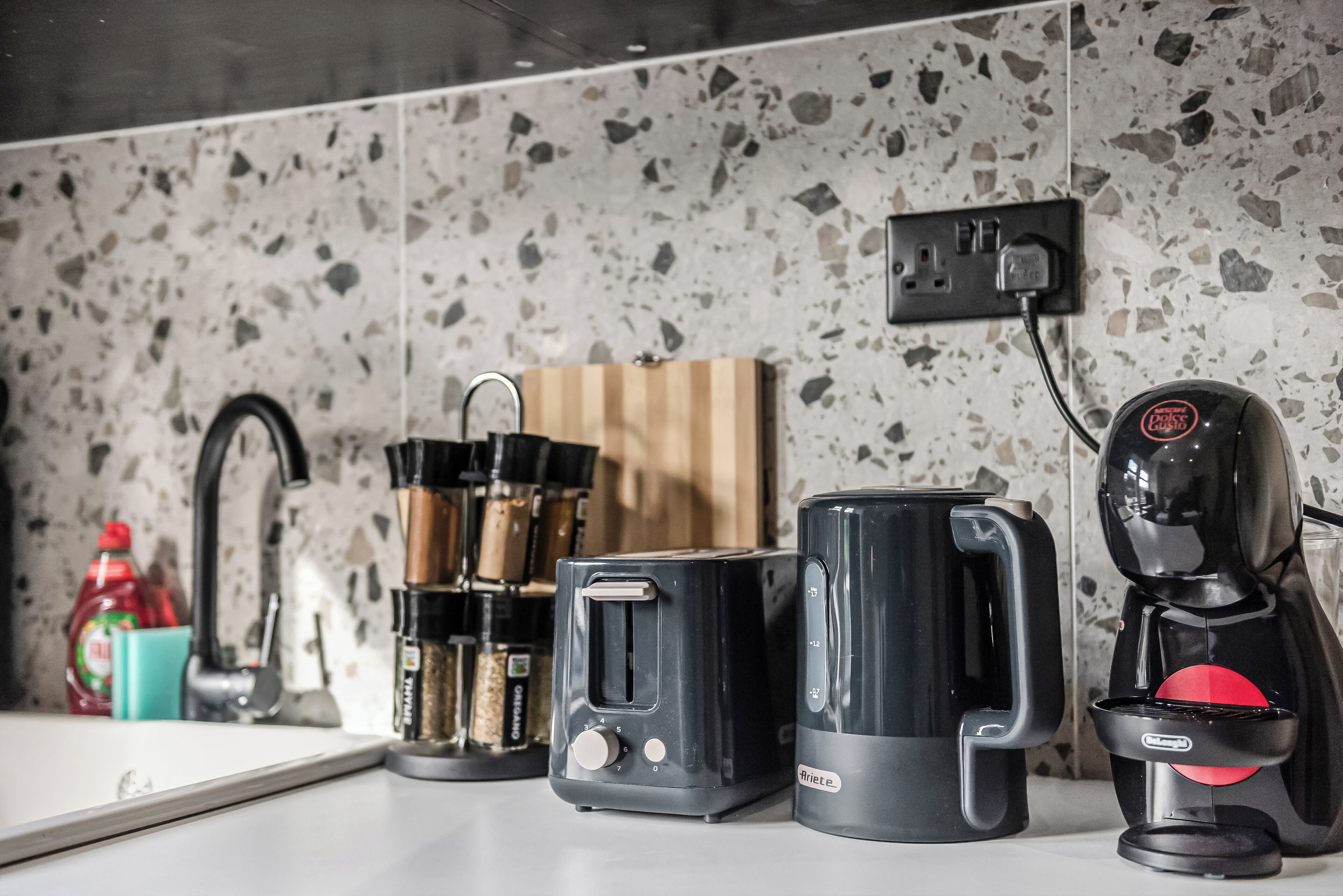 A kitchen counter with a toaster, a coffee maker, and a knife block.