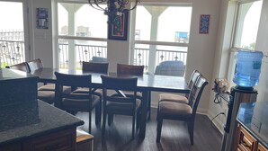 A kitchen with a dining area, wooden cabinets, a granite countertop, and a chandelier. - LAKE HOUSE. Serene, charming 5-bedroom house in greater New Orleans. (New Orleans)
