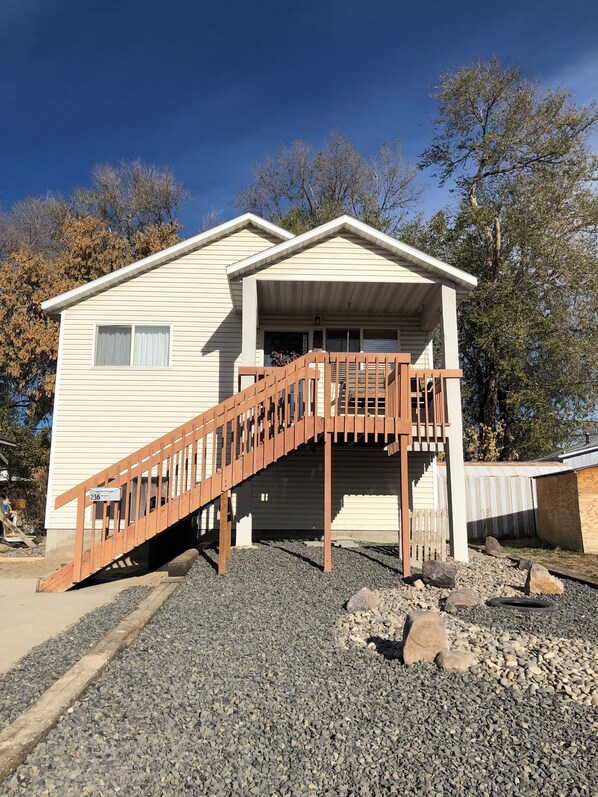A single-story house with a wooden staircase leading to a front porch.