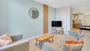 Una sala de estar moderna con un sofá, una mesa de centro y un televisor.