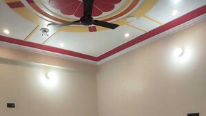 Una habitación con cama, ventilador de techo y lámpara.