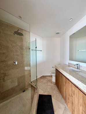 A modern bathroom with a glass-enclosed shower, a wooden vanity, and a large mirror. - Penthouse Navela 405, by Cercana (Telchac Puerto)