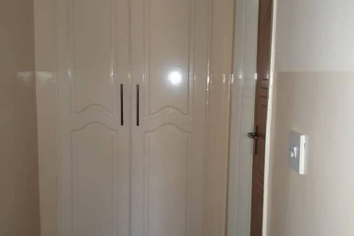 Une porte double blanche, avec une poignée, un interrupteur et un cadre de porte.