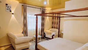 Un dormitorio con cama con dosel, un sofá y una silla.