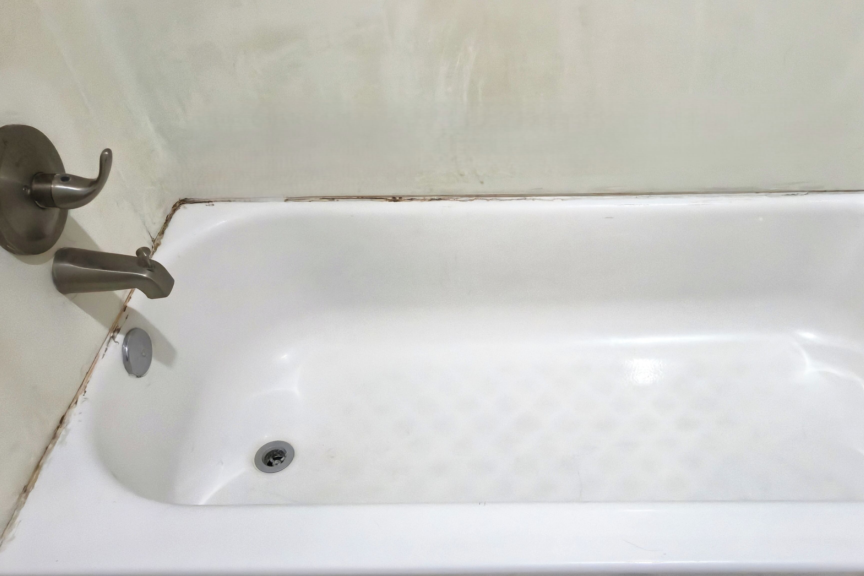 A white bathtub with a single faucet and a drain.