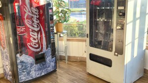Two vending machines, one with a Coca-Cola logo and the other with a push button. - Cole Manor Motel By OYO Love Field Market Center (Dallas)