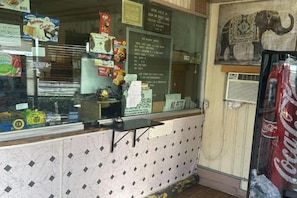 A snack bar with various food items and a Coca-Cola refrigerator.