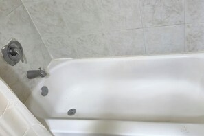 Une baignoire blanche avec un robinet et un drain.