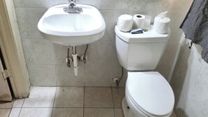 A bathroom with a white sink, toilet, and tiled floor. - Cole Manor Motel By OYO Love Field Market Center (Dallas)