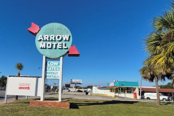 A motel sign with a circular design and directional arrows. - Arrow Motel By Oyo Near Downtown (Orlando)