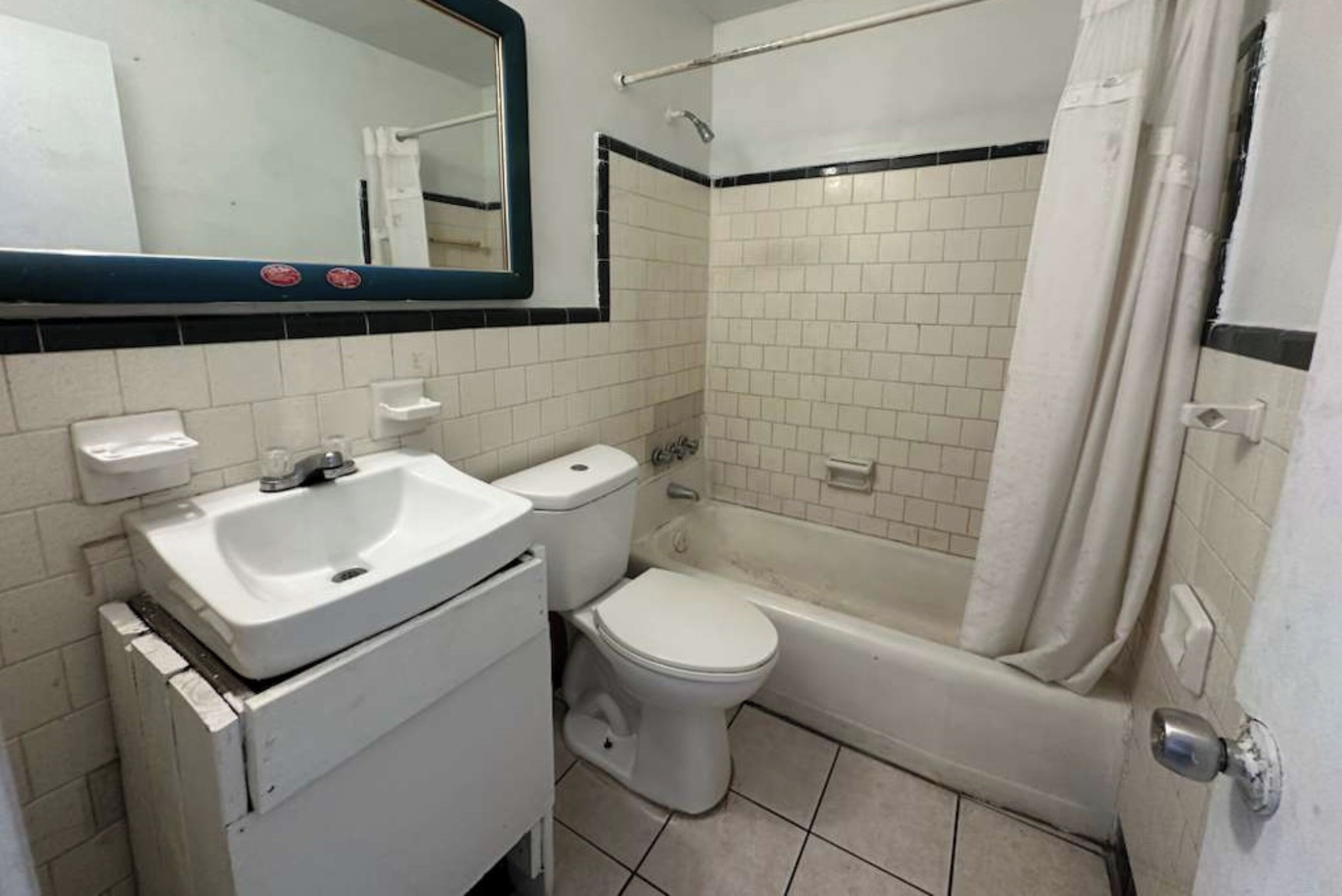Een badkamer met een wit wastafel, toilet en bad.