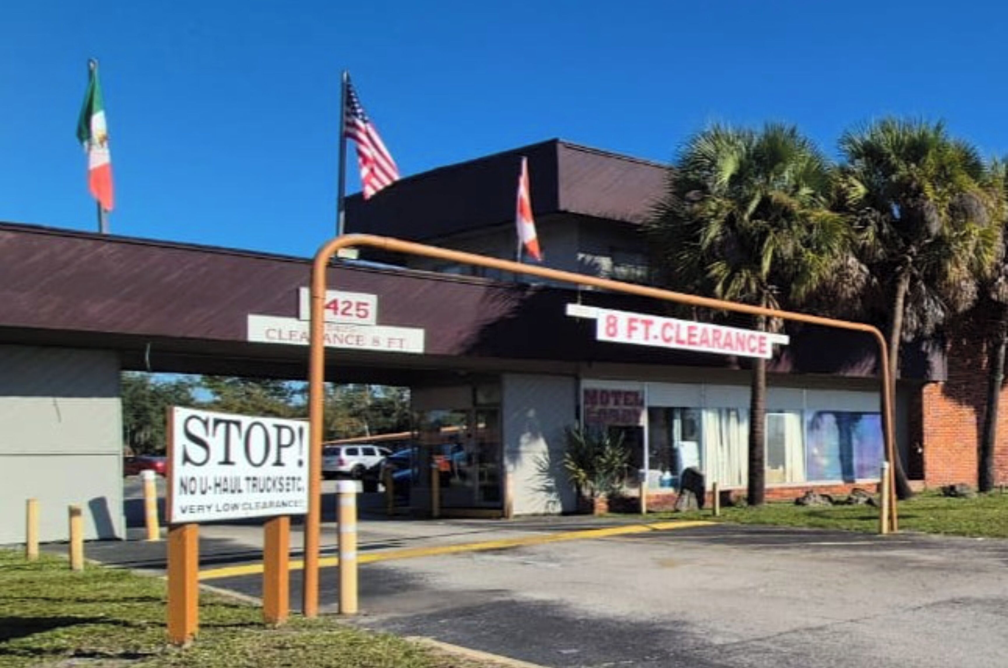 A motel with a 425 clearance sign, 8 ft clearance sign, and a 'NO U-Haul Trucks' sign.